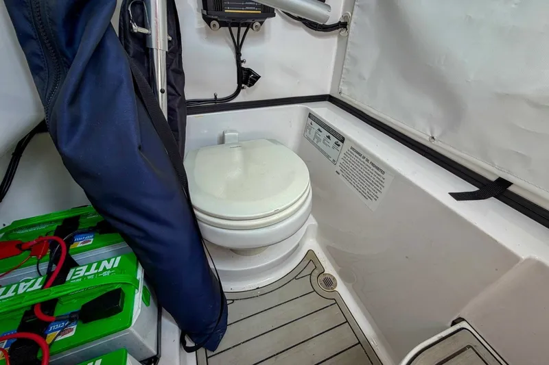 Slide: The Image of 2023 Sportsman Heritage 261 Center Console boat interior with toilet and battery storage. - 55