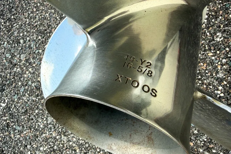 Slide: The Image of Close-up of a stainless steel boat propeller with engraved specifications. - 80