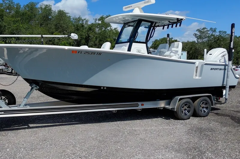 Slide: The Image of 2023 Sportsman Heritage 261 Center Console boat on trailer, parked outdoors. - 11
