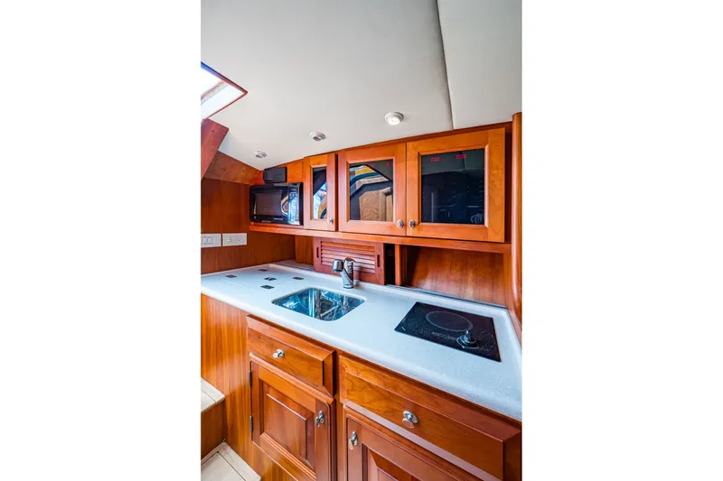 Slide: The Image of Luxurious 2008 Hinckley Talaria 38R Convertible yacht kitchen with wood cabinetry and modern appliances. - 11