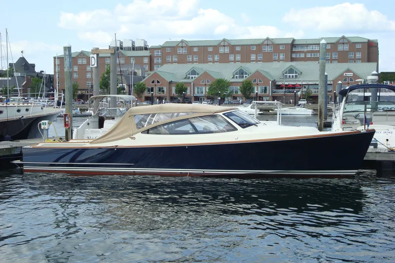 The Image of 2008 Hinckley Talaria 38R Convertible yacht docked in a marina, with buildings in the background. - 0