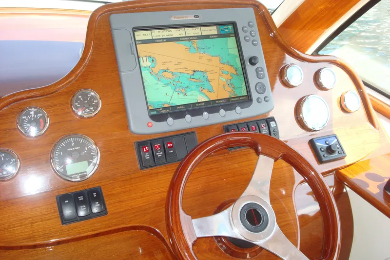 Slide: The Image of Hinckley Talaria 38R Convertible 2008 dashboard with navigation system and wooden steering wheel. - 4