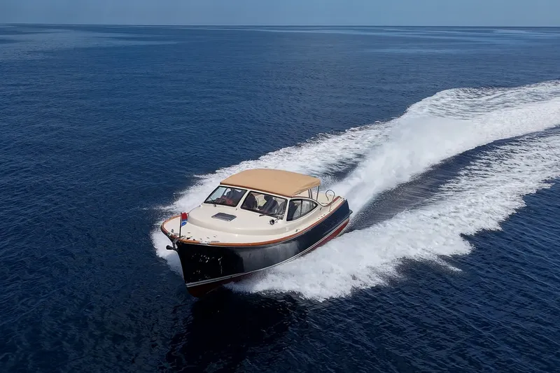 Slide: The Image of 2008 Hinckley Talaria 38R Convertible cruising on open water, creating a wake. - 4