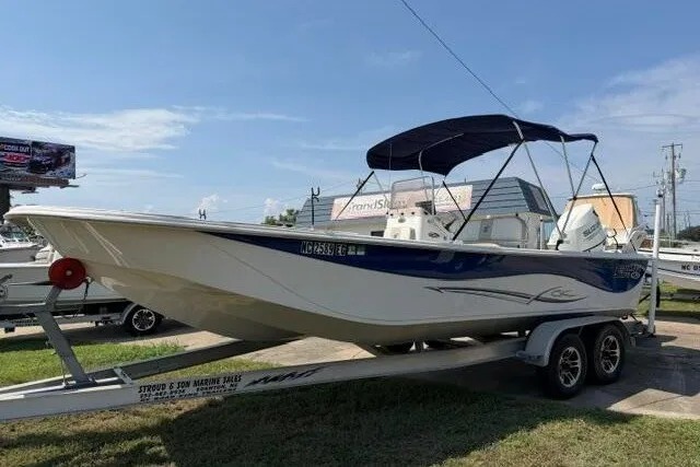 Slide: The Image of 2017 Carolina Skiff 238 DLV boat on trailer, featuring a blue and white design with a canopy. - 7