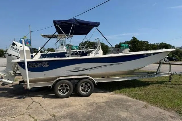 The Image of 2017 Carolina Skiff 238 DLV boat on trailer with canopy and Suzuki outboard motor. - 0