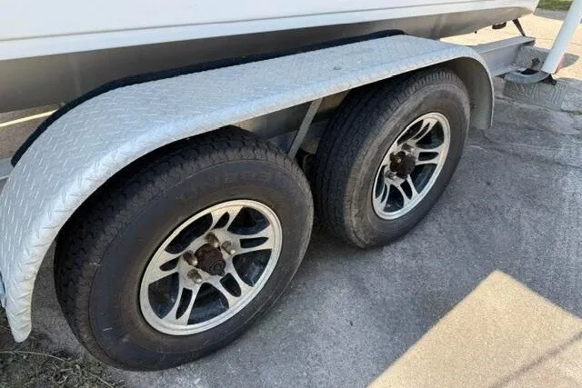 Slide: The Image of Trailer wheels of a 2017 Carolina Skiff 238 DLV boat on pavement. - 9