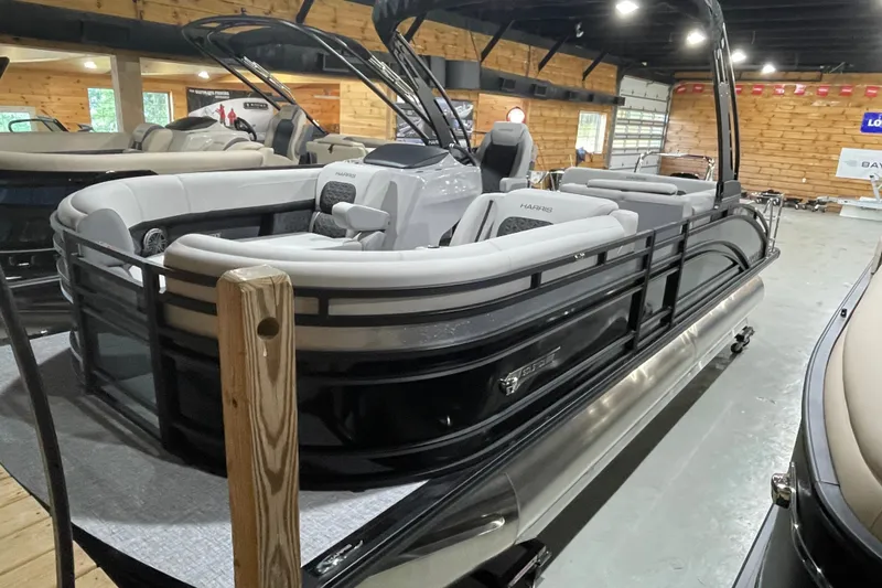 Slide: The Image of 2027 Harris Solstice 230 SL pontoon boat in showroom, featuring sleek design and luxurious seating. - 19