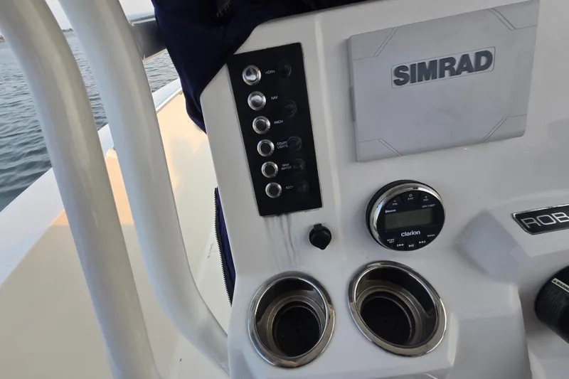 Slide: The Image of 2021 Robalo R200 Center Console dashboard with Simrad display and Clarion audio system. - 13