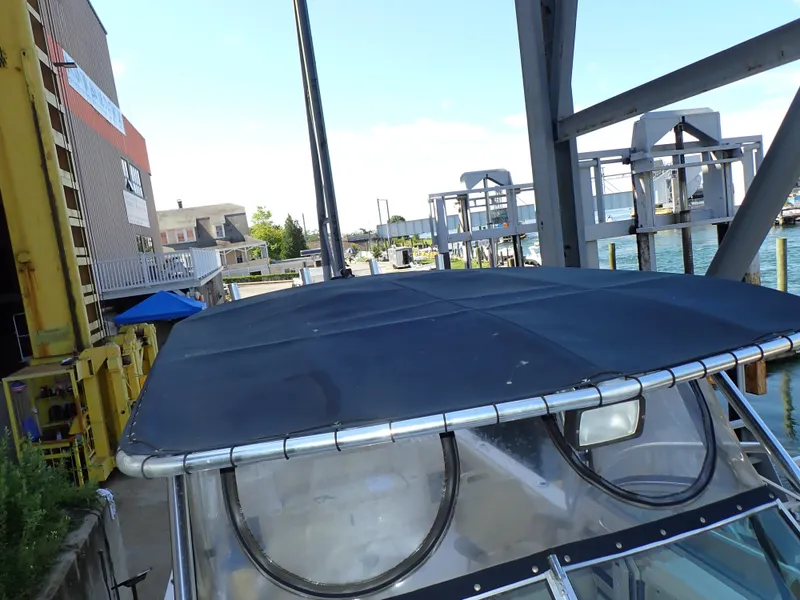 Slide: The Image of A 2003 Grady-White Gulfstream 232S with a black canopy, docked at a marina. - 15