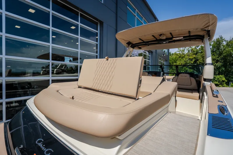 Slide: The Image of 2026 Chris-Craft Sportster 28 boat with beige seating, docked near a modern building. - 14