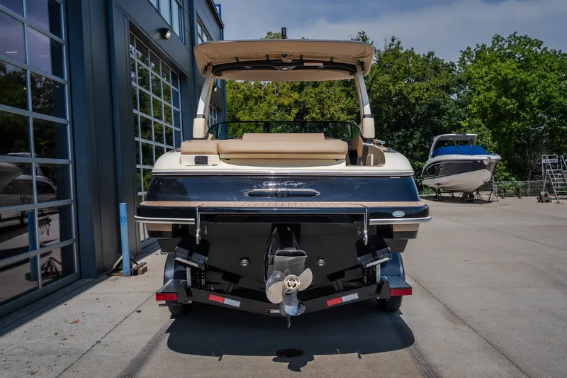 Slide: The Image of 2026 Chris-Craft Sportster 28 boat, rear view, parked outdoors near a building. - 6