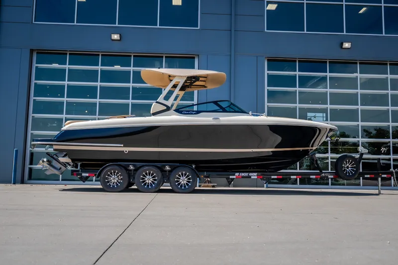 The Image of 2026 Chris-Craft Sportster 28 boat on trailer, parked outside modern building. - 1