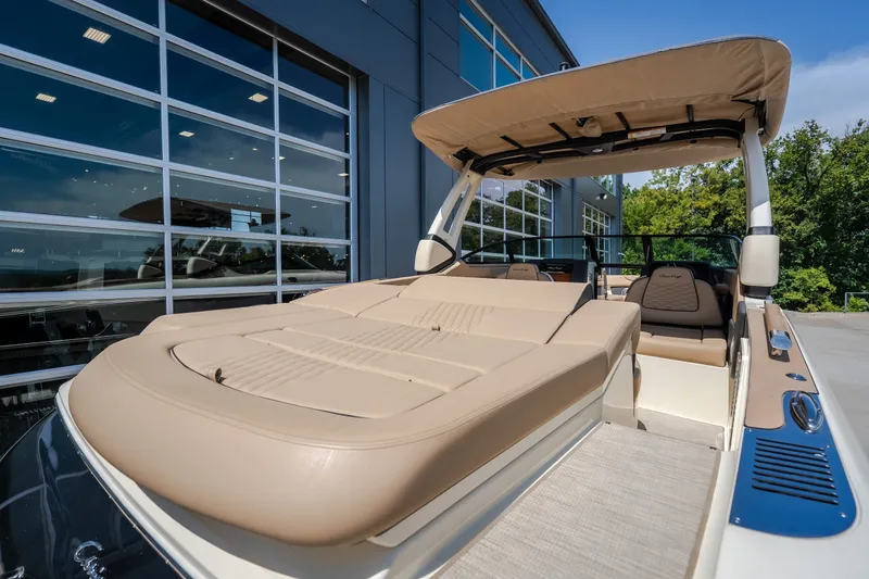 Slide: The Image of 2026 Chris-Craft Sportster 28 boat with beige seating, docked near modern building. - 13