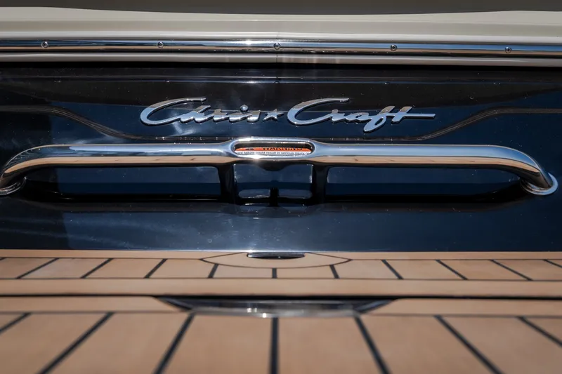 Slide: The Image of 2026 Chris-Craft Sportster 28 boat with sleek chrome detailing and wooden deck. - 8
