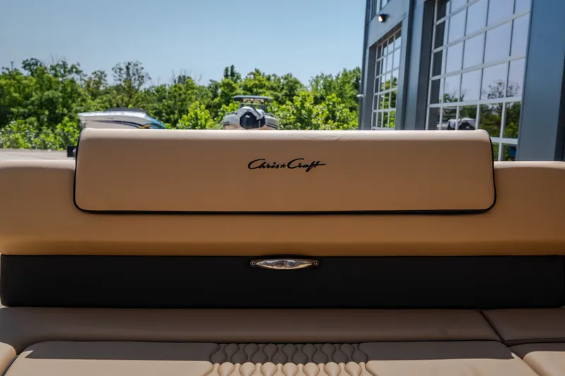 Slide: The Image of 2026 Chris-Craft Sportster 28 boat interior with beige seating and logo. - 22