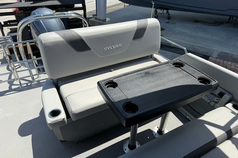 Slide: The Image of 2022 Sylvan L3 DLZ boat interior with seating and table featuring cup holders. - 11