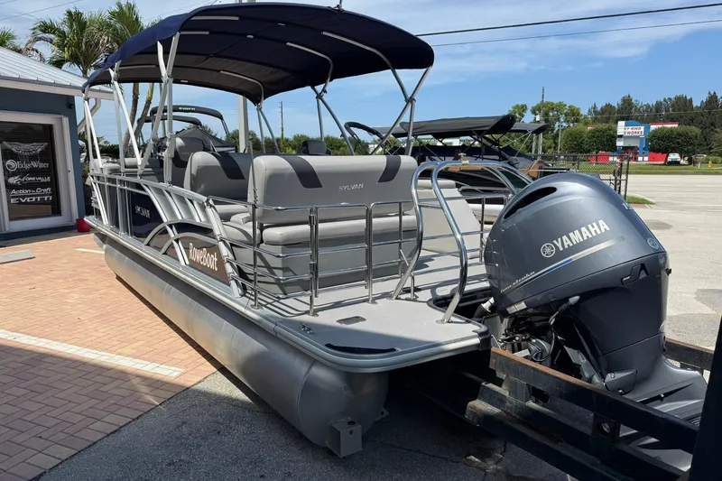 Slide: The Image of 2022 Sylvan L3 DLZ pontoon boat with Yamaha outboard motor, parked on a sunny day. - 5
