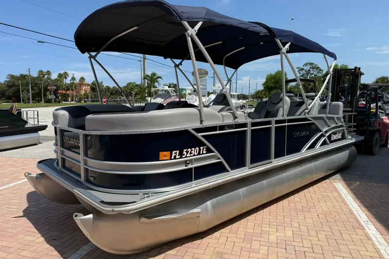 Slide: The Image of 2022 Sylvan L3 DLZ pontoon boat with canopy, parked on a sunny day. - 3