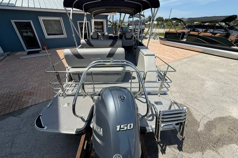 Slide: The Image of 2022 Sylvan L3 DLZ pontoon boat with Yamaha 150 engine, docked outdoors. - 6
