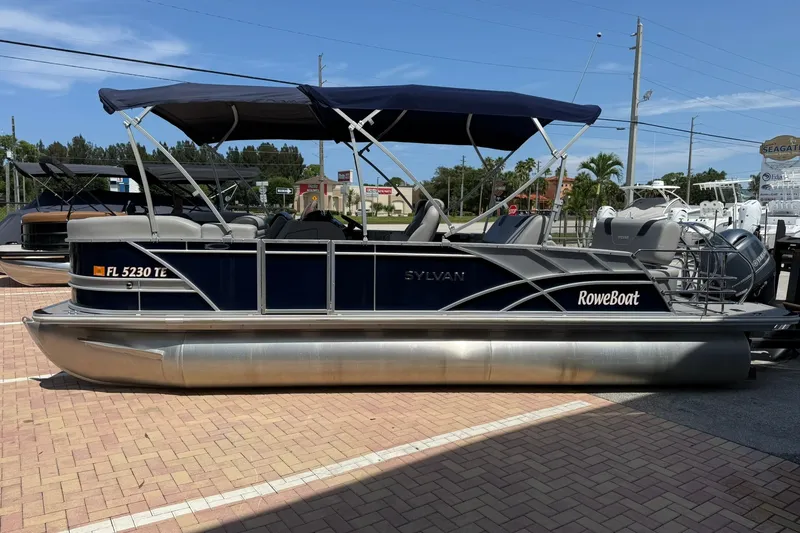 Slide: The Image of 2022 Sylvan L3 DLZ pontoon boat with canopy, parked on brick pavement. - 4