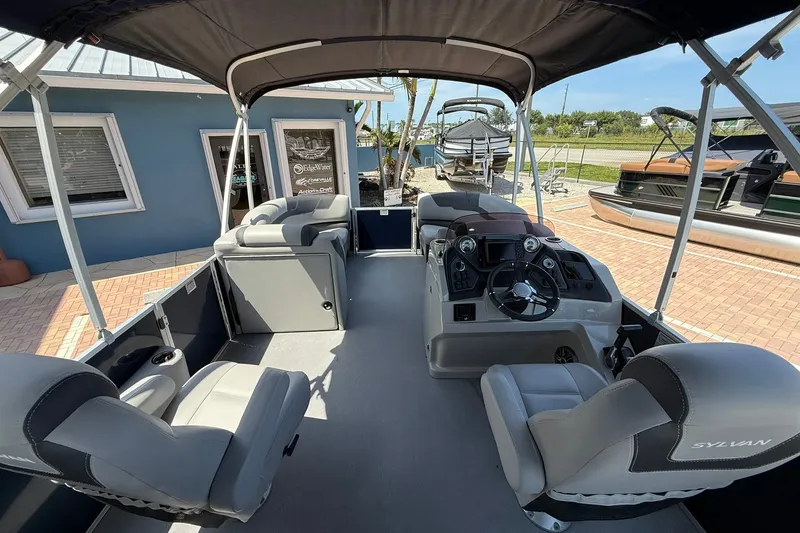 Slide: The Image of 2022 Sylvan L3 DLZ pontoon boat interior with helm, seating, and canopy. - 13
