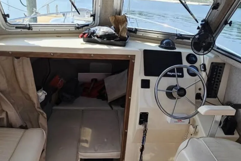 Slide: The Image of 2004 Parker 2520 Modified Vee Sport Cabin interior with steering wheel and navigation equipment. - 10