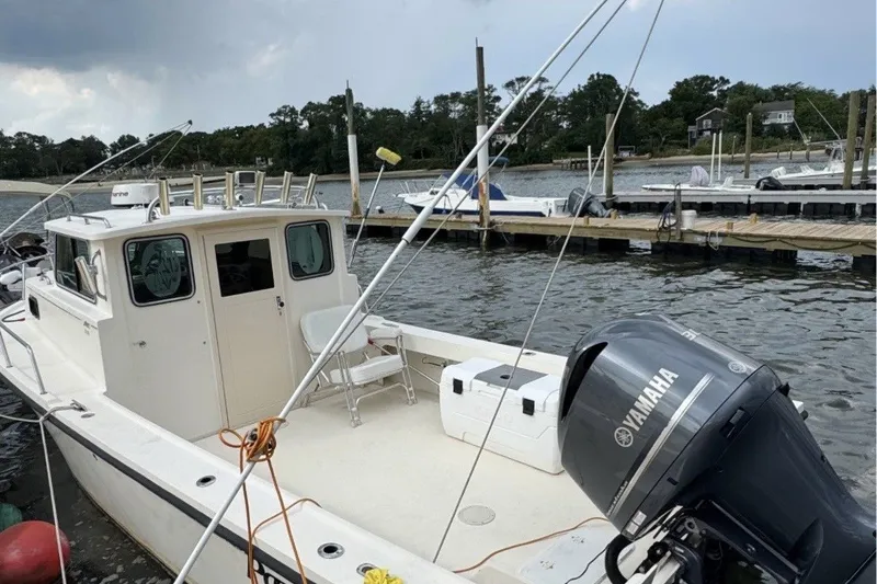 Slide: The Image of 2004 Parker 2520 Modified Vee Sport Cabin boat docked with Yamaha outboard motor. - 1