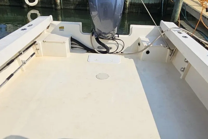 Slide: The Image of 2004 Parker 2520 Modified Vee Sport Cabin boat deck with outboard motor, docked at marina. - 5