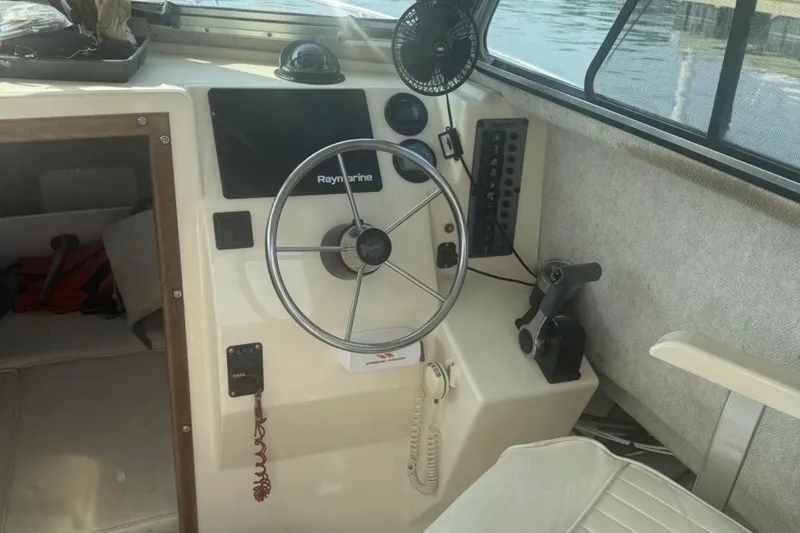 Slide: The Image of 2004 Parker 2520 Modified Vee Sport Cabin helm with Raymarine electronics and steering wheel. - 2