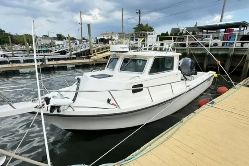 Slide: The Image of 2004 Parker 2520 Modified Vee Sport Cabin boat docked at a marina. - 8
