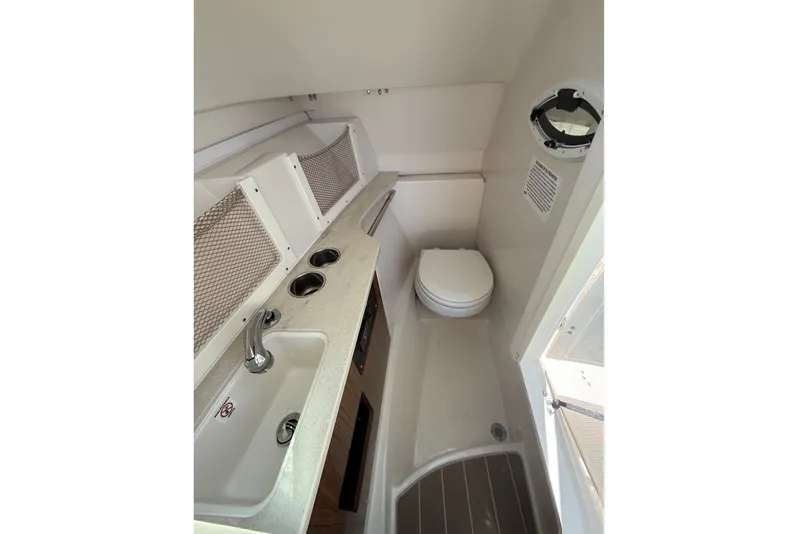 Slide: The Image of 2022 Sailfish 245 DC boat interior with sink and toilet in compact cabin. - 14