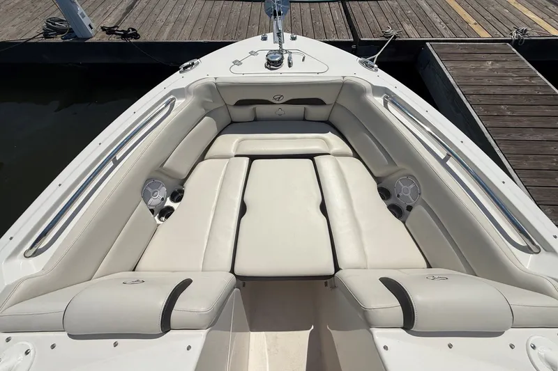 Slide: The Image of 2022 Sailfish 245 DC boat interior with white cushioned seating and cup holders. - 19