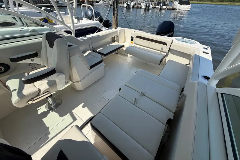 Slide: The Image of 2022 Sailfish 245 DC boat interior with spacious seating and modern design by the water. - 12