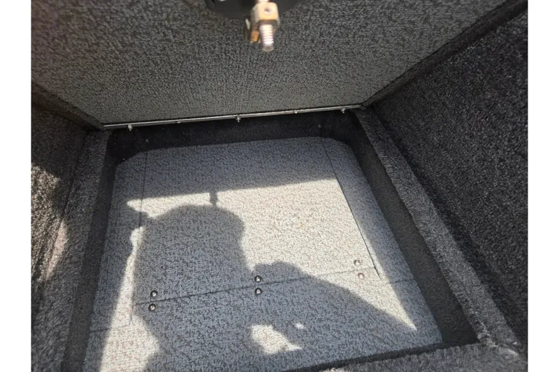 Slide: The Image of 2014 Lund 1900 Tyee boat storage compartment with carpeted interior and shadow. - 18