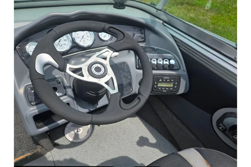 Slide: The Image of Steering wheel and dashboard of 2014 Lund 1900 Tyee boat, featuring gauges and controls. - 15