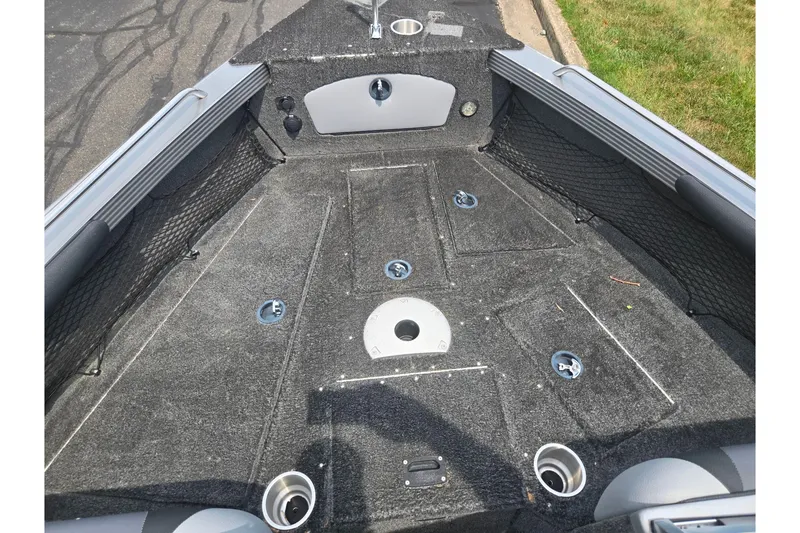 Slide: The Image of 2014 Lund 1900 Tyee boat interior with carpeted deck and storage compartments. - 19