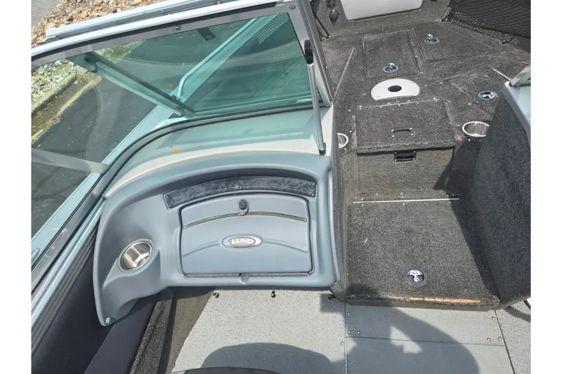Slide: The Image of 2014 Lund 1900 Tyee boat interior with carpeted deck and storage compartments. - 16
