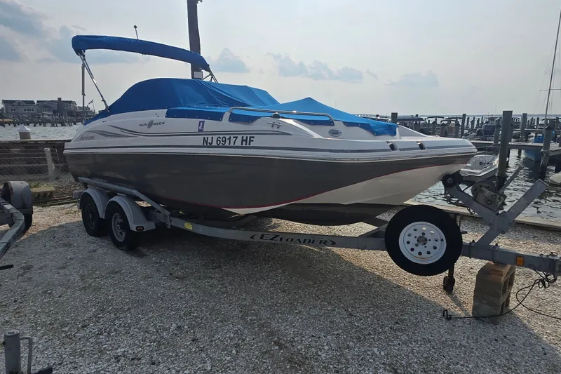 Slide: The Image of 2014 Hurricane SunDeck 187 OB boat on trailer, dockside with blue cover. - 0