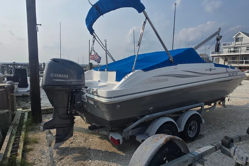 Slide: The Image of 2014 Hurricane SunDeck 187 OB boat with Yamaha outboard motor on trailer at marina. - 4