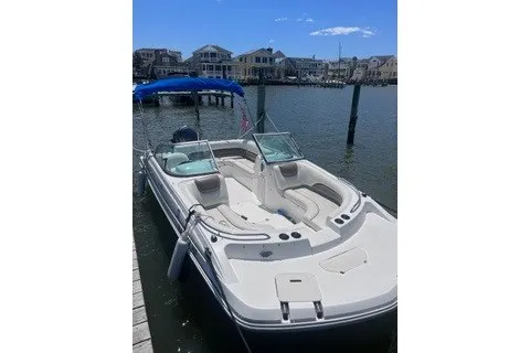 Slide: The Image of 2014 Hurricane SunDeck 187 OB boat docked by waterfront homes under clear blue sky. - 6