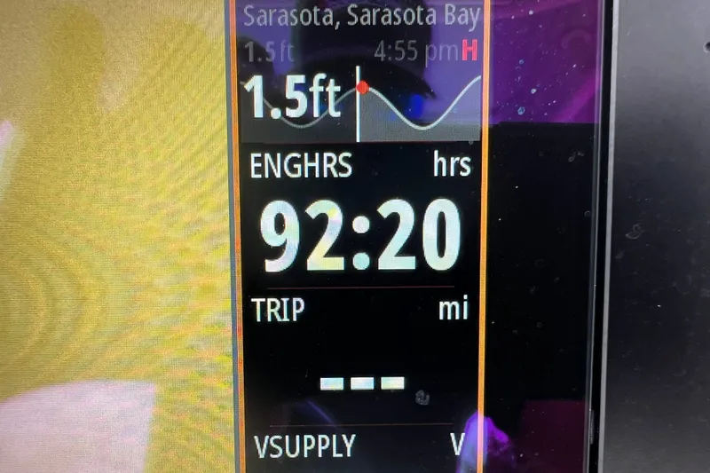 Slide: The Image of Display screen showing engine hours and tide information on a 2024 Robalo 266 Cayman. - 15