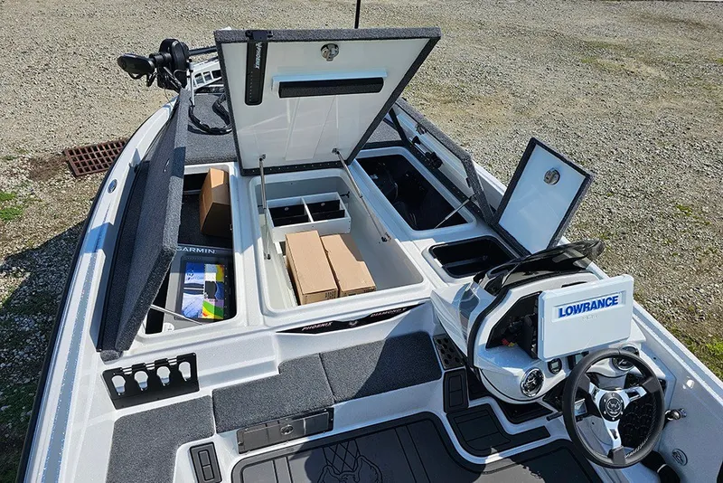 Slide: The Image of 2027 Phoenix 921 Elite X boat interior with open storage compartments and navigation equipment. - 24