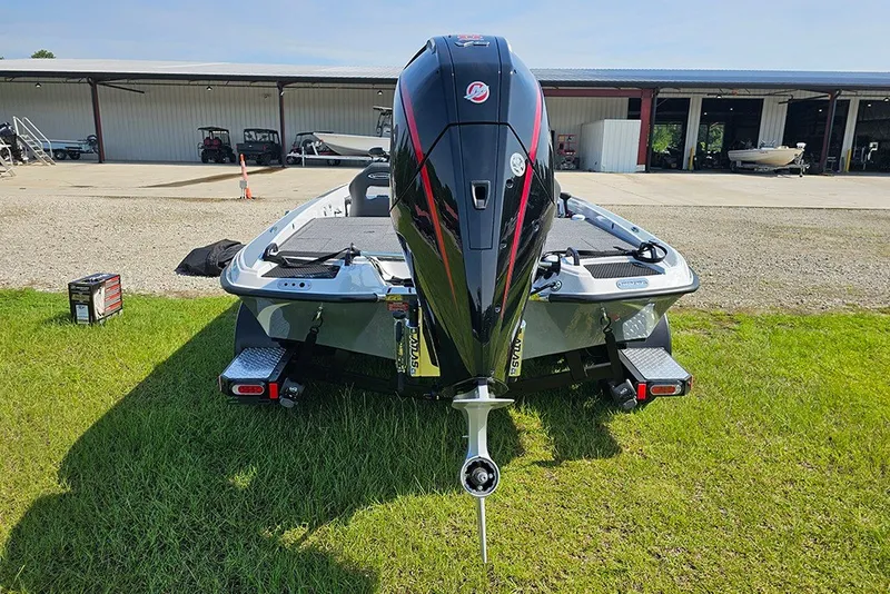 Slide: The Image of 2027 Phoenix 921 Elite X boat with powerful outboard motor, parked on grass near storage facility. - 8