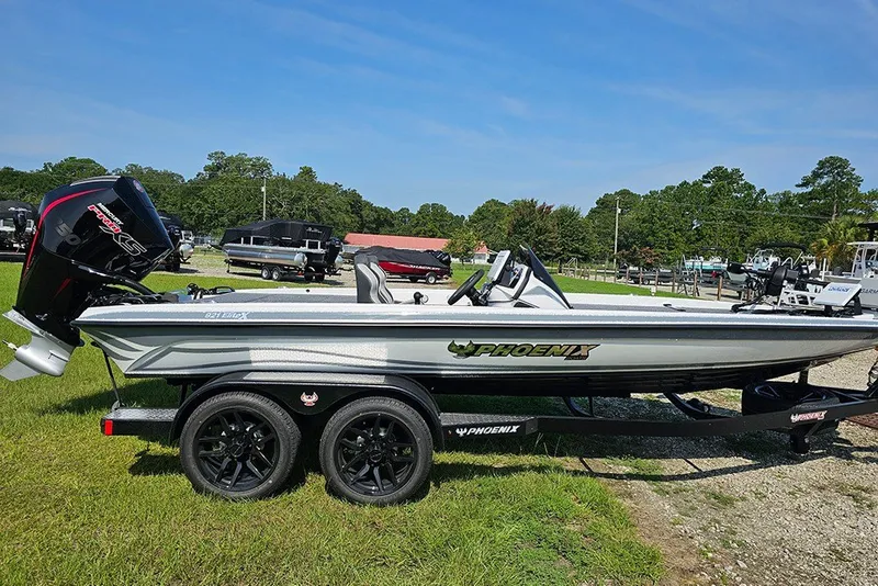 The Image of 2027 Phoenix 921 Elite X boat on trailer, parked on grass under clear sky. - 1