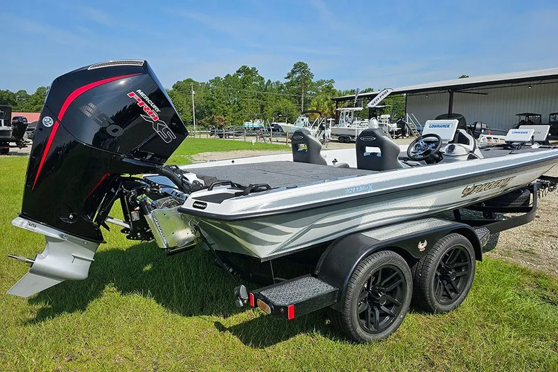 Slide: The Image of 2027 Phoenix 921 Elite X boat with powerful outboard motor on a grassy area. - 3