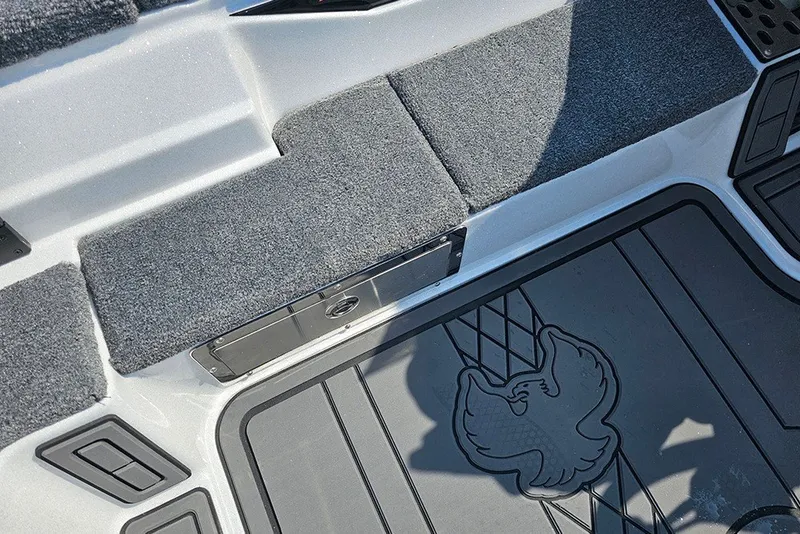Slide: The Image of 2027 Phoenix 921 Elite X boat interior with carpeted seating and eagle emblem flooring. - 18