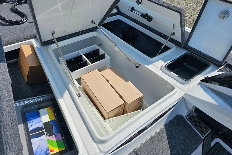 Slide: The Image of Open storage compartments in a 2027 Phoenix 921 Elite X boat, featuring organized boxes and a Garmin device. - 27