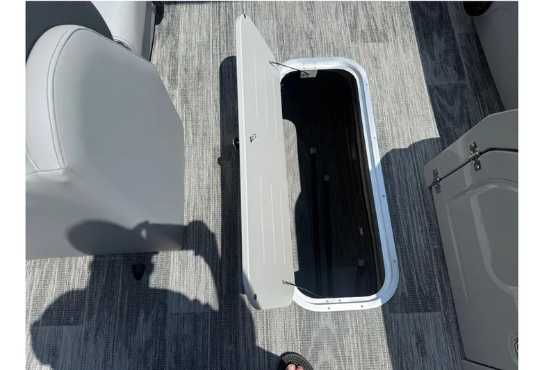 Slide: The Image of 2026 Bentley Pontoons Legacy 243 Navigator interior storage compartment open on gray flooring. - 9