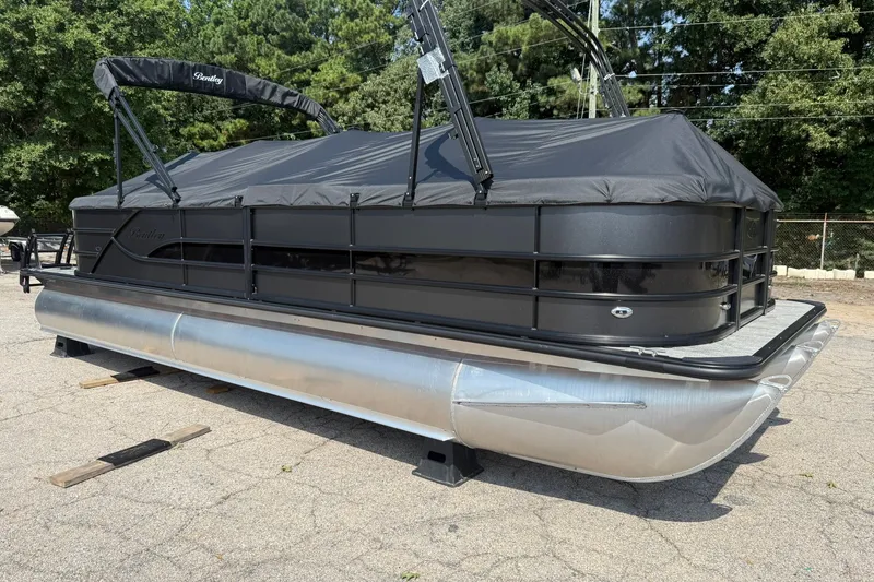 Slide: The Image of 2026 Bentley Pontoons Legacy 243 Navigator with black cover, parked outdoors. - 15