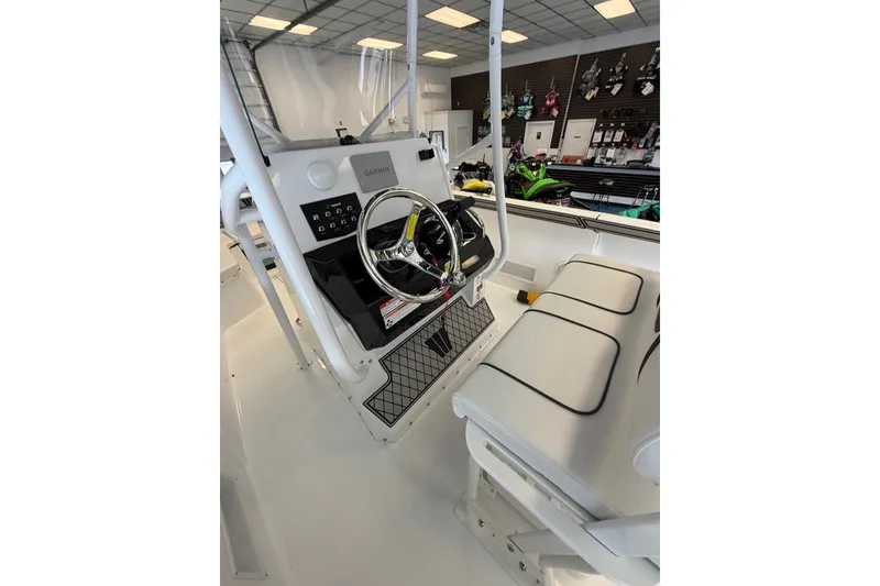 Slide: The Image of 2027 Wellcraft 202 Fisherman boat interior with steering wheel and seating in showroom. - 23